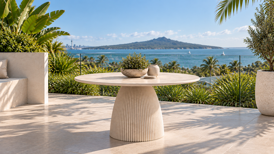 Rangitoto Sandstone Beige round outdoor dining table in a coastal setting, 1200 x 750 mm
