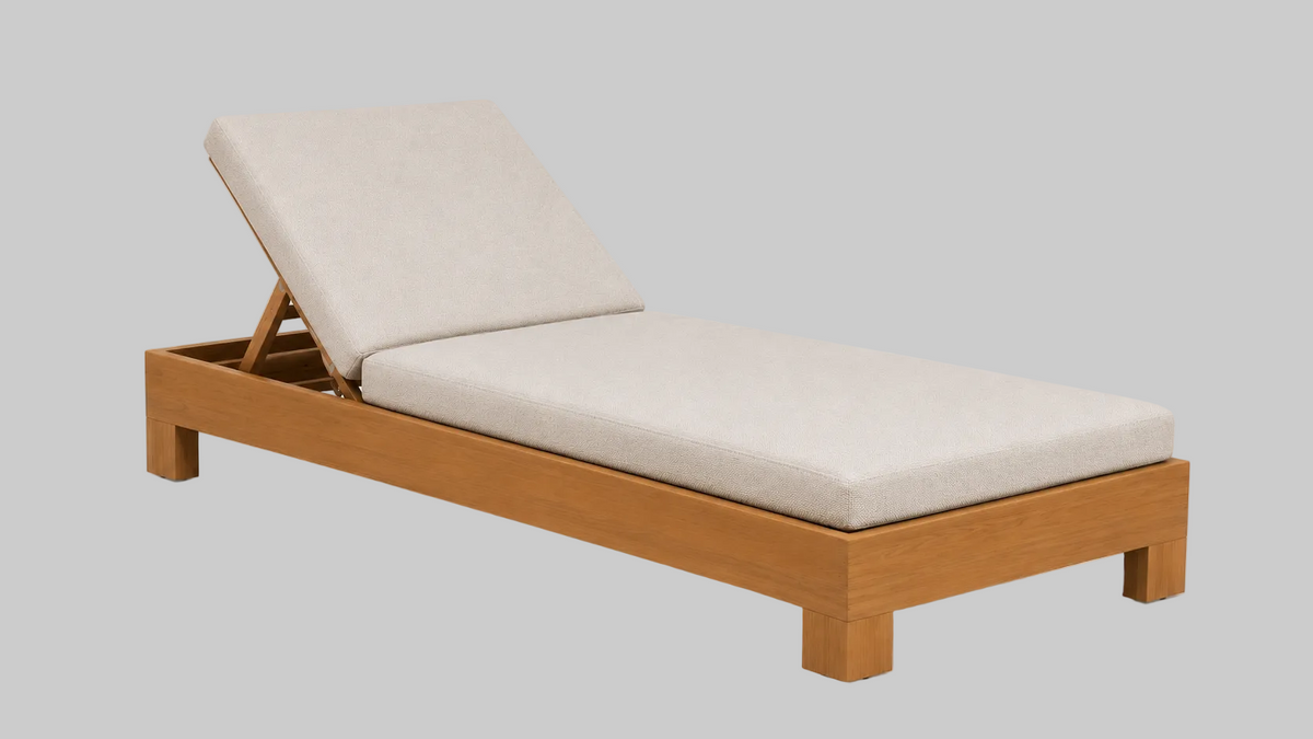 A modern teak chaise lounger daybed with a light beige Sunbrella upholstered cushion
