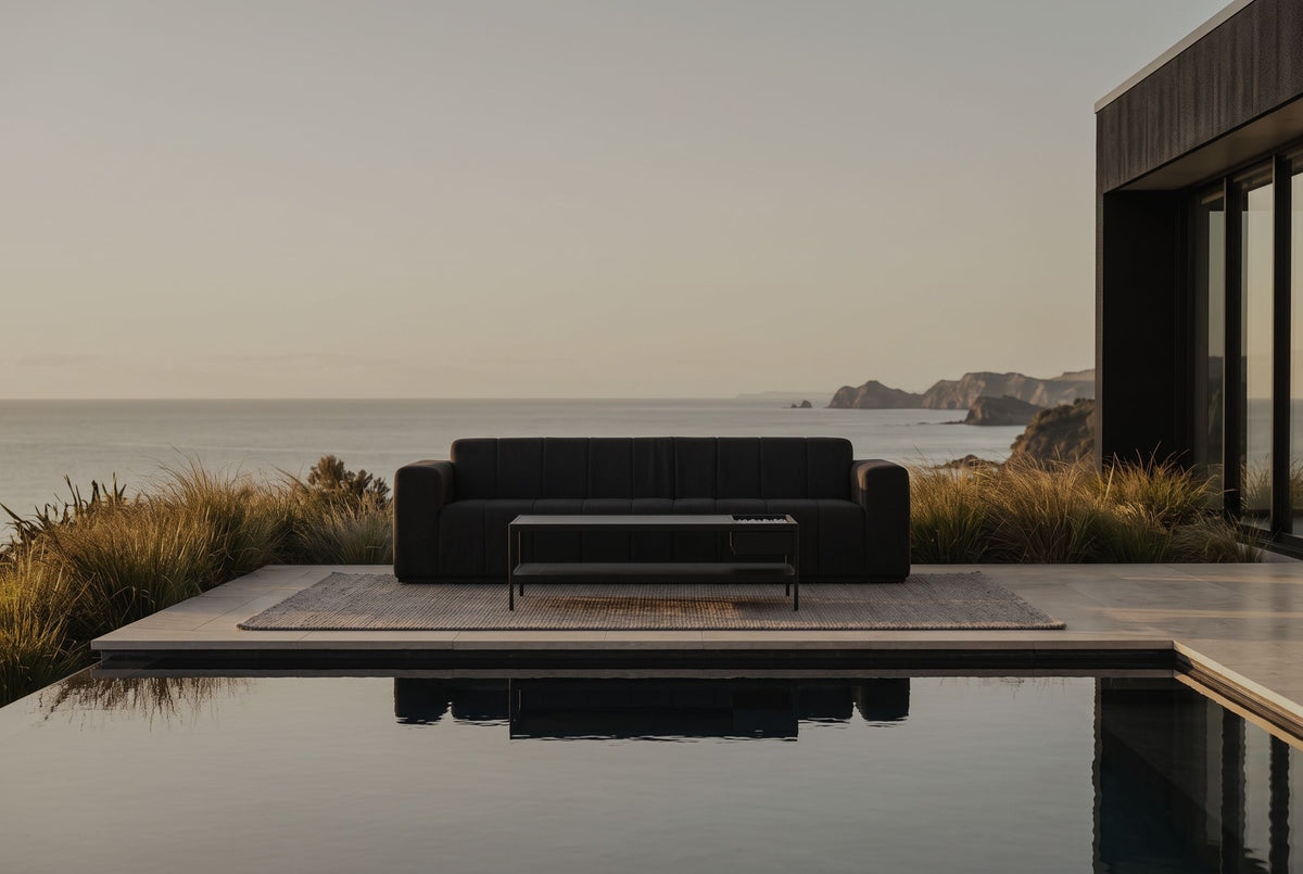 Matakana modular sofa mirrored in an infinity pool above the ocean at golden hour