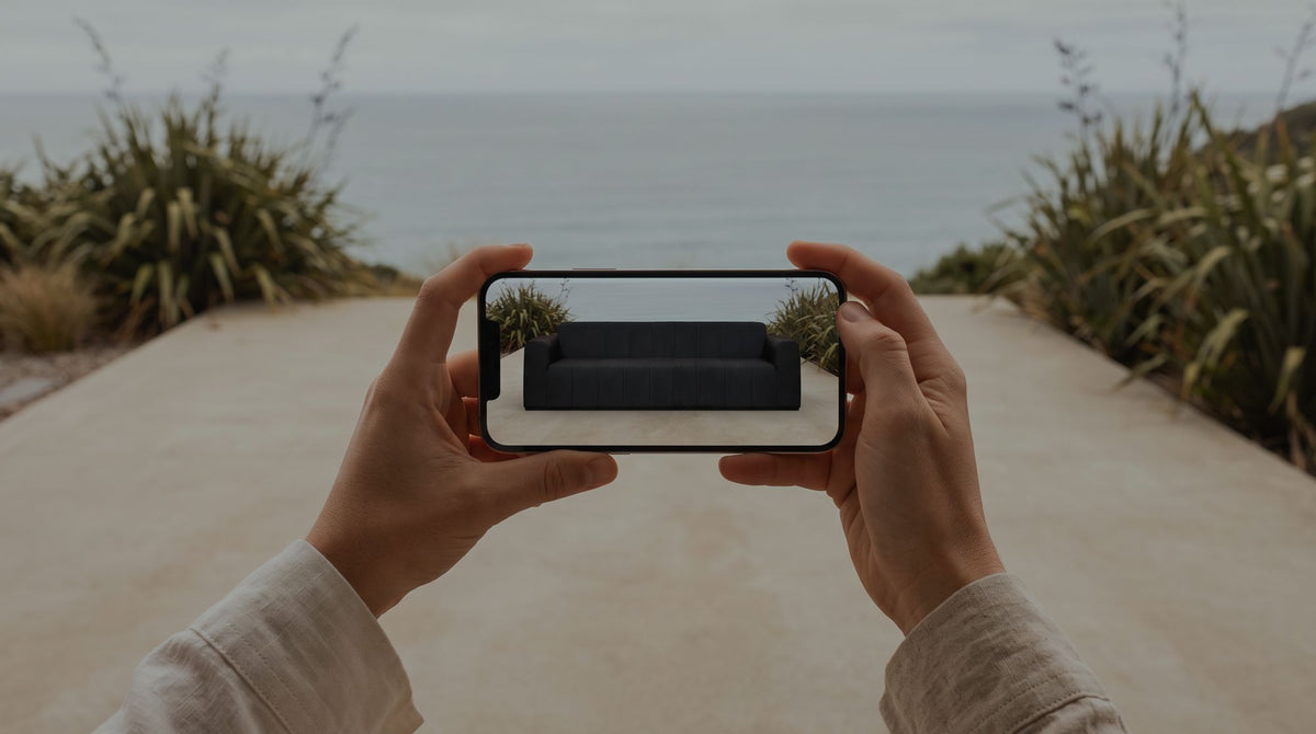 A phone previewing a Matakana sofa on an empty terrace