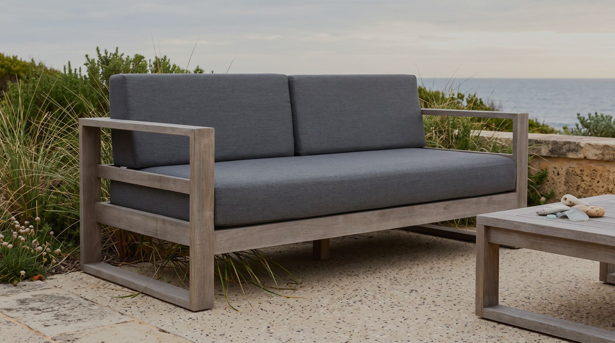 Tasman teak sofa weathered to silver on a mature terrace