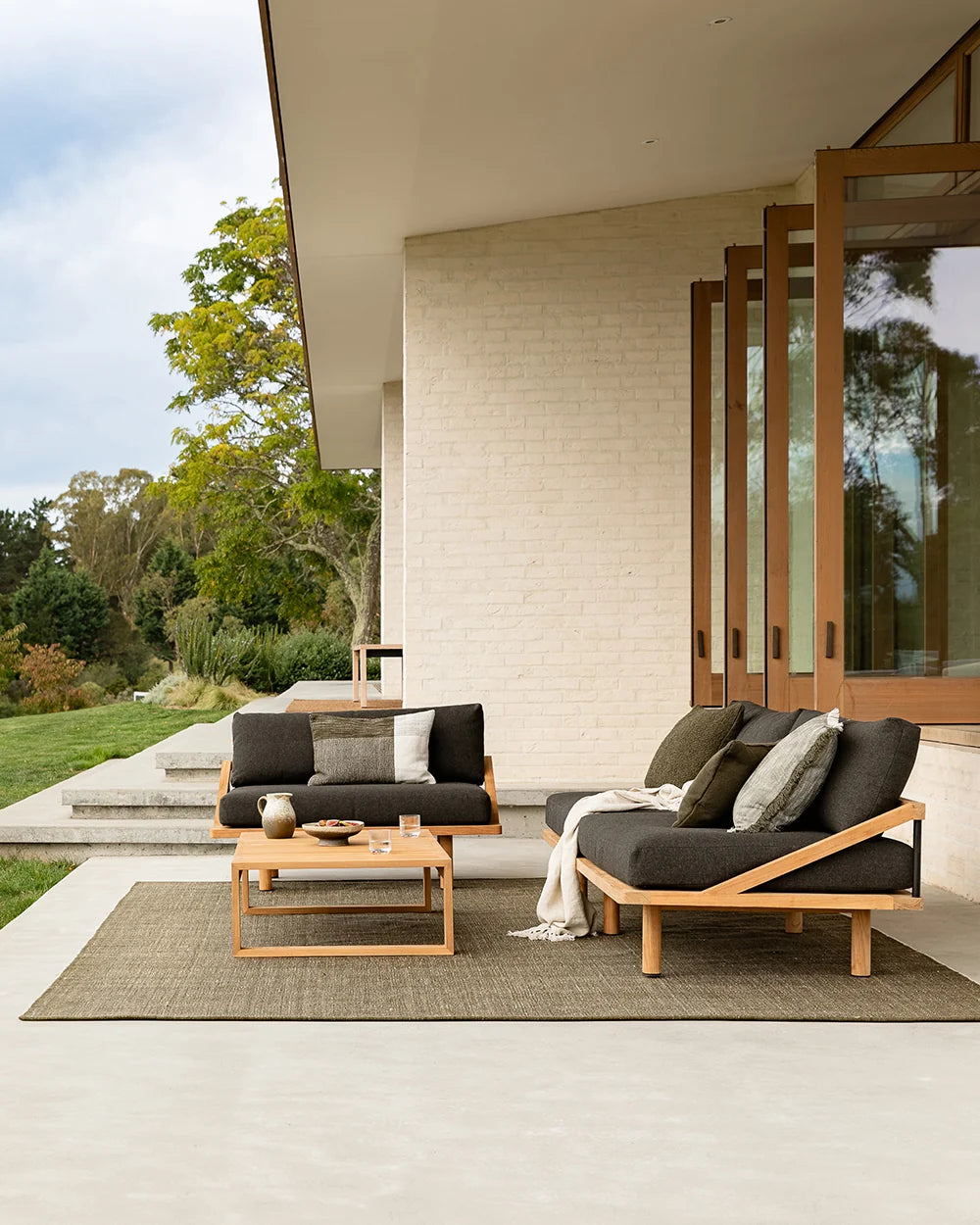 Lonsdale Outdoor Floor Rug in Olive styled in a covered outdoor dining space