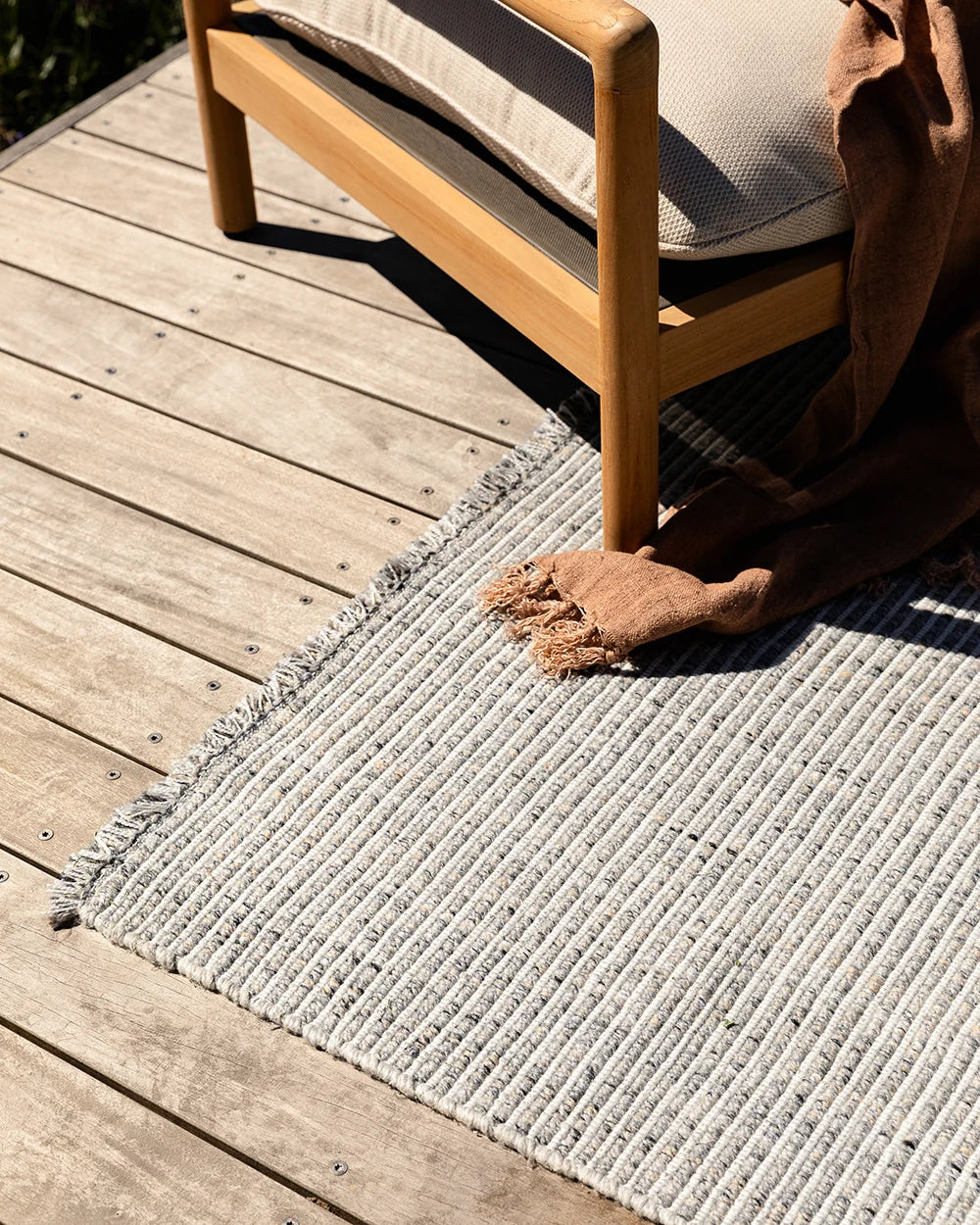 Rhodes Outdoor Floor Rug in Slate styled in a covered outdoor living space