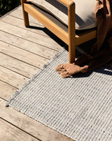 Rhodes Outdoor Floor Rug in Slate styled in a covered outdoor living space