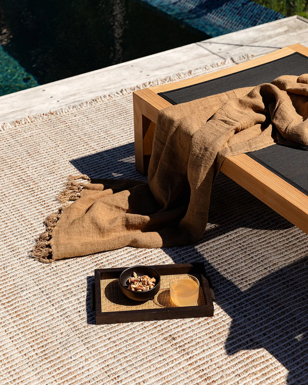 Rhodes Outdoor Floor Rug in Teak styled in a covered outdoor living space